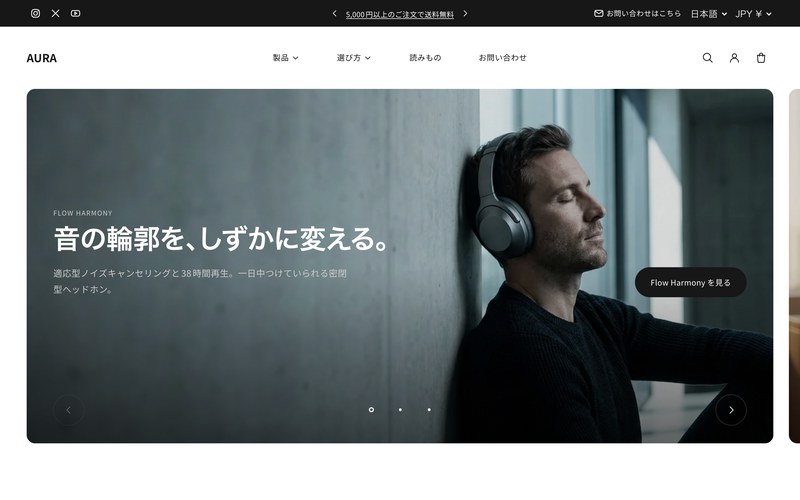 AURAのデモストアのトップページ。ヘッドフォンを着けた人物の写真を画面いっぱいに敷き、白抜きの見出しを重ねた暗色基調の構成。
